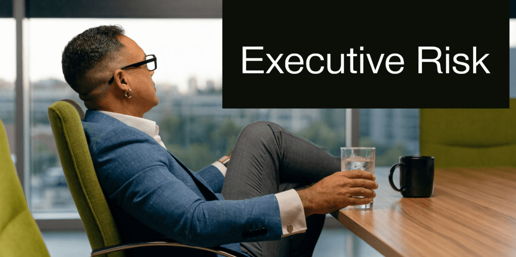 Executive seated at desk holding a glass of water, illustrating the sedentary posture and dehydration risks that contribute to hamstring cramps
